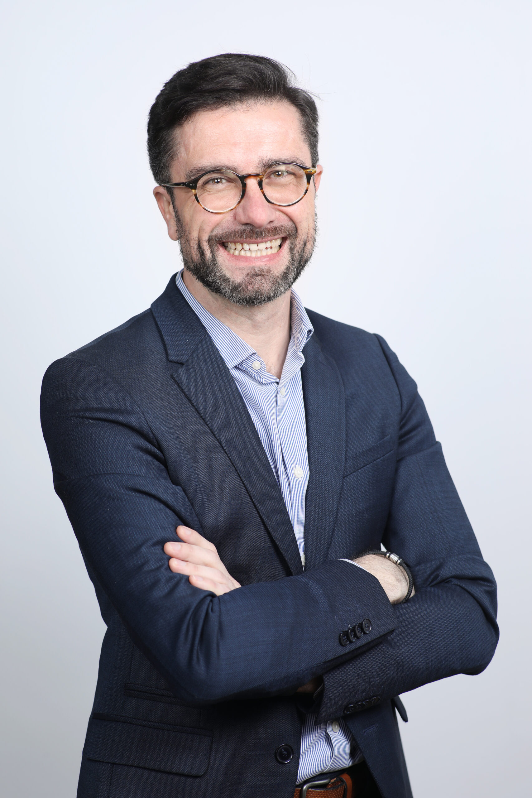 Photo d'Adrien Floirat souriant habillé d'un costume bleue.
